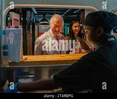 Le roi Charles III visite le stand Desi Loco Indian Street Food et commande un rouleau de saag paneer kathi et un samosa au poulet au beurre lors d’une visite à Nairobi Street Kitchen pour célébrer la scène culturelle et créative kenyane et rencontrer de jeunes créatifs, notamment des artisans, des créateurs de mode, des musiciens et des artistes, le deuxième jour de la visite d'État au Kenya. Date de la photo : mercredi 1 novembre 2023. Banque D'Images