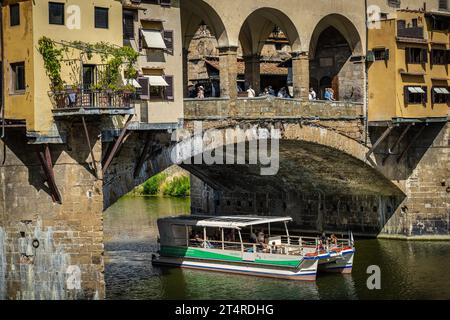 Florence, Italie — 1 septembre 2023. Un bateau d'excursion sur l'Arno glisse sous le Ponte Vecchio. Banque D'Images