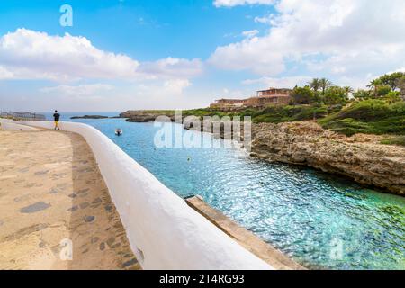Une petite baie de crique le long de la mer Méditerranée au village balnéaire blanchi à la chaux de Binibeca Vell, Espagne sur l'île des Baléares de Minorque. Banque D'Images