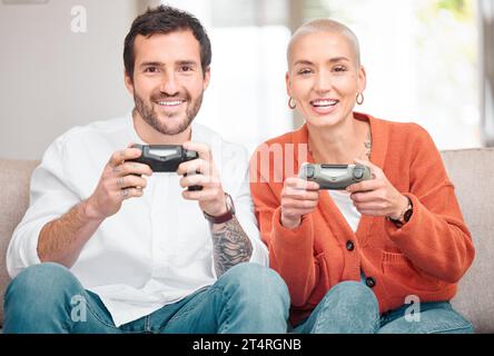 Un couple qui joue ensemble, reste ensemble. Portrait recadré d'un jeune couple affectueux jouant à des jeux vidéo à la maison. Banque D'Images