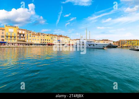 Yachts et boutiques de luxe et cafés-terrasses dans le port coloré et le village de Saint-Tropez France le long de la mer Méditerranée et la Côte d'Azur Banque D'Images