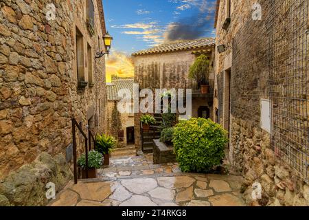 Les rues médiévales en pierre de Pals Espagne au coucher du soleil après une tempête de pluie d'été le long de la Costa Brava côte de la mer Méditerranée à Girona e Banque D'Images