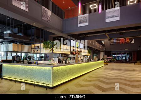 Comptoir de bar dans le hall, avec panneau de verre jaune rétro-éclairé, avec balcon du hall. Theater Zuidplein, Rotterdam, Rotterdam, pays-Bas. Architecte : de Zwar Banque D'Images