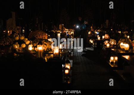 Varsovie, Pologne. 01 novembre 2023. On voit des gens visiter des tombes dans un cimetière à Varsovie, en Pologne, le 01 novembre 2023. La Toussaint en Pologne est l'un des jours publics les plus importants où des millions de personnes visitent des cimetières pour allumer des bougies et apporter des fleurs aux défunts. (Photo Jaap Arriens/Sipa USA) crédit : SIPA USA/Alamy Live News Banque D'Images