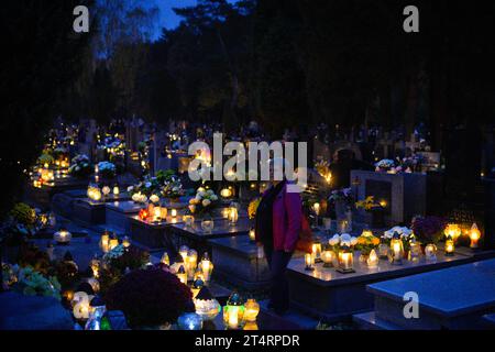 Varsovie, Pologne. 01 novembre 2023. On voit des gens visiter des tombes dans un cimetière à Varsovie, en Pologne, le 01 novembre 2023. La Toussaint en Pologne est l'un des jours publics les plus importants où des millions de personnes visitent des cimetières pour allumer des bougies et apporter des fleurs aux défunts. (Photo Jaap Arriens/Sipa USA) crédit : SIPA USA/Alamy Live News Banque D'Images