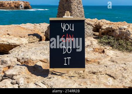 Vous pouvez le faire symbole. Mot concept vous pouvez le faire sur un beau tableau noir de craie noire. Beau fond de mer bleu pierre rouge. Motivation de l'entreprise Banque D'Images