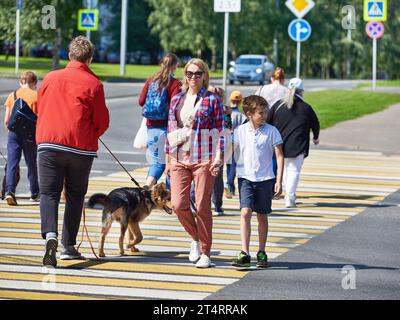 Une femme et un enfant traversent la route à un passage pour piétons Banque D'Images