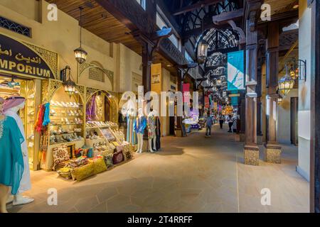 Magasins colorés vendant des cadeaux, des souvenirs et des vêtements à l'intérieur du Souk Madinat Jumeirah, un marché commercial haut de gamme et un centre commercial à Dubaï, aux Émirats arabes Unis Banque D'Images