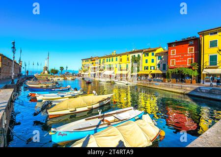 LAZISE, VÉNÉTIE - ITALIE - 28 SEPTEMBRE 2018 : bateaux dans le port de la vieille ville de Lazise et touristes marchant le matin. La ville est un desti de vacances populaire Banque D'Images