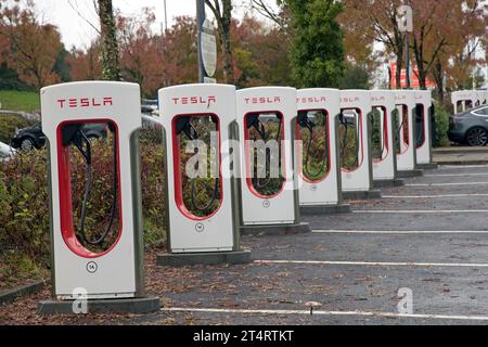 Gamme de chargeurs de véhicules électriques haute vitesse Tesla inutilisés dans l'aire de repos de l'autoroute M4 à la jonction 47. Banque D'Images