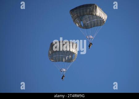 Zone d'entraînement de Pohakuloa, États-Unis. 31 octobre 2023. Les parachutistes de l'armée américaine, avec la 11e division aéroportée descendent en parachutes après avoir sauté d'un avion de transport C-17 lors du multinational joint Pacific multinational Readiness Center 24-01 dans la zone d'entraînement de Pohakuloa, le 31 octobre 2023 à Mauna Loa, Hawaï. Crédit : SPC. Wyatt Moore/US Army/Alamy Live News Banque D'Images