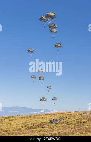 Zone d'entraînement de Pohakuloa, États-Unis. 31 octobre 2023. Les parachutistes de l'armée américaine, avec la 11e division aéroportée descendent en parachutes après avoir sauté d'un avion de transport C-17 lors du multinational joint Pacific multinational Readiness Center 24-01 dans la zone d'entraînement de Pohakuloa, le 31 octobre 2023 à Mauna Loa, Hawaï. Crédit : SPC. Mariah Aguilar/US Army/Alamy Live News Banque D'Images