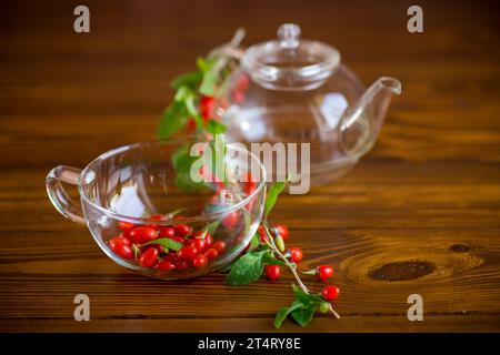 Branche avec baie de goji rouge mûre sur une table en bois brun Banque D'Images