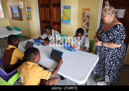 Accra, Ghana. 31 octobre 2023. Des étudiants utilisent des tablettes dans une bibliothèque multimédia construite à partir de bouteilles en plastique recyclées à Kokrobite, une communauté de pêcheurs située à la périphérie d’Accra, au Ghana, le 31 octobre 2023. Une médiathèque, construite à partir de bouteilles en plastique recyclées par un architecte africain, a été inaugurée mardi dernier à Kokrobite, offrant aux écoliers de familles pauvres un accès à un éventail de ressources pédagogiques. Crédit : Seth/Xinhua/Alamy Live News Banque D'Images