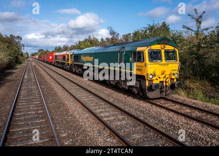 BURTON UPON TRENT, ROYAUME-UNI - 3 OCTOBRE 2023. Deux locomotives de fret Freightliner intermodales de classe 66 remorquant un train de conteneurs maritimes en campagne Banque D'Images