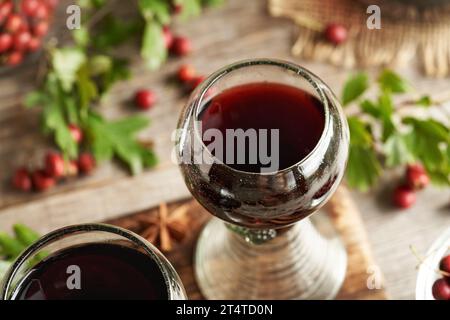 Un verre de vin médicinal avec des baies fraîches d'aubépine Banque D'Images