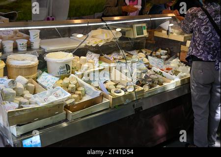 Paris, France. Juin 30 2022. Au beau marché local marché Popincourt, à un comptoir de fromages avec toutes les spécialités françaises. Un client est shopp Banque D'Images