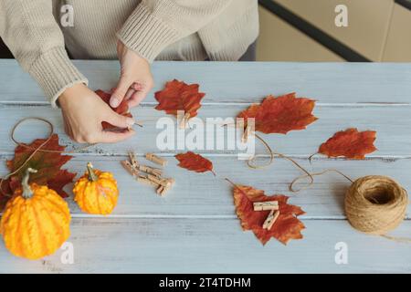 Guirlande maison de feuilles d'automne colorées avec des mains de femmes Banque D'Images