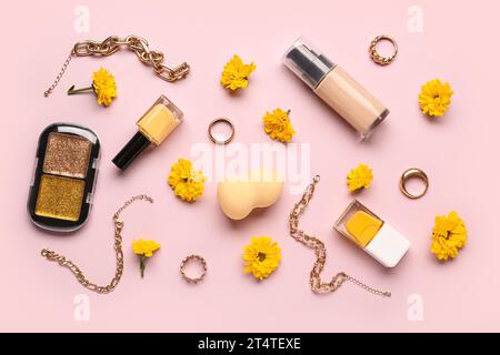 Composition avec des produits de maquillage et de belles fleurs de chrysanthème sur fond rose Banque D'Images