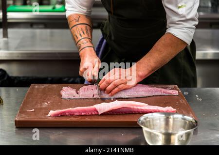 Le chef Ingo Mark démontre la coupe fine du filet sur une carpe argentée. Les os y sont coupés à intervalles de 2 mm afin qu'ils n'interfèrent plus avec l'alimentation. Wiesau (VGem), Allemagne Banque D'Images