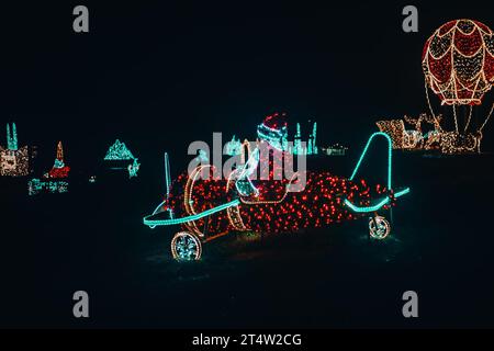 Décor de rue de Noël dans l'obscurité. Père Noël sur une installation lumineuse d'hélicoptère. Banque D'Images