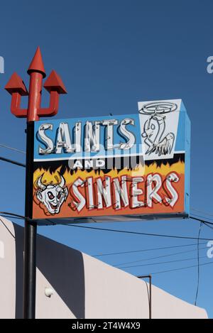 Enseigne au néon de couleur vive avec un trident rouge pour Saints and Sinners, un magasin d'alcool, établi en 1963, Espanola, Nouveau-Mexique, États-Unis, États-Unis. Banque D'Images