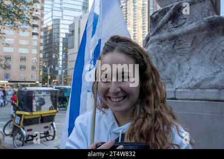 New York, États-Unis. 01 novembre 2023. NEW YROK, NEW YORK - NOVEMBRE 01 : une femme tient un drapeau israélien lors d'une veillée aux chandelles pour les 1400 victimes des attaques terroristes du Hamas en Israël le 7 octobre à Central Park le 1 novembre 2023 à New York. Des milliers de civils, Palestiniens et Israéliens, sont morts depuis le 7 octobre 2023, après que le terroriste palestinien du Hamas basé dans la bande de Gaza est entré dans le sud d’Israël dans une attaque sans précédent déclenchant une guerre déclarée par Israël au Hamas. Crédit : Ron Adar/Alamy Live News Banque D'Images