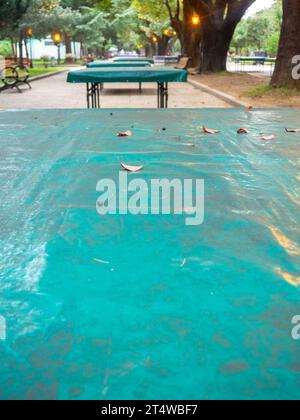 Tables de ping-pong recouvertes de bâche. Protéger la bouche de la pluie. Concept de fin d'été dans le parc. sport dans le parc. vacances à la station. Personne Banque D'Images