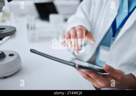 Hôpital, médecin et mains avec tablette pour la recherche, l'innovation médicale et le travail. Clinique, typage et analyse chimique avec professionnel et laboratoire Banque D'Images