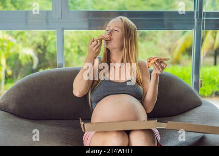 Une femme enceinte apprécie une tranche de pizza, savourant un moment de plaisir tout en satisfaisant son envie d'un régal délicieux et réconfortant. Excité Banque D'Images