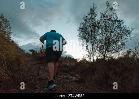 L'homme s'entraîne dans les montagnes dans sa lutte contre le surpoids. Banque D'Images