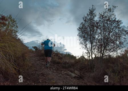 L'homme s'entraîne dans les montagnes dans sa lutte contre le surpoids. Banque D'Images