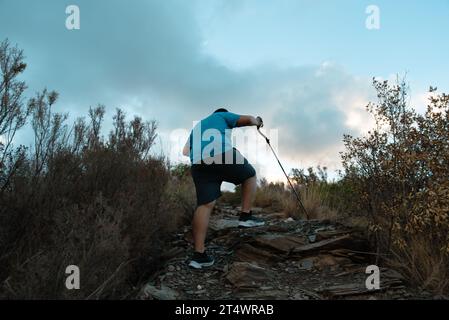 L'homme s'entraîne dans les montagnes dans sa lutte contre le surpoids. Banque D'Images