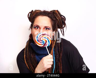 Alternative dreadlocked femme caucasienne avec des couleurs vives colorées et ludiques et sucette Banque D'Images