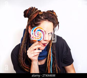 Alternative dreadlocked femme caucasienne avec des couleurs vives colorées et ludiques et sucette Banque D'Images