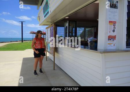 Femme attendant au café Bek-Topia sur l'Esplanade, Cooktown, sud de la péninsule de Cape York, Queensland, Australie. Pas de MR ou PR Banque D'Images