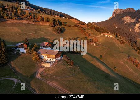 Santa Maddalena, Italie - vue panoramique aérienne du village de Santa Maddalena au coucher du soleil. Paysage d'automne avec maisons tyroliennes traditionnelles, sommets de montagne a Banque D'Images