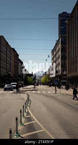 Longue rue à Gamlastan, Stockholm, Suède avec des maisons sombres sur le côté. Au bout de la route un grand bâtiment, Avicii Arena. Banque D'Images