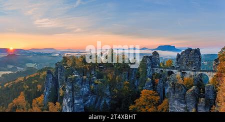 Une large photo panoramique de 2:1 d'un lever de soleil d'automne avec vue depuis le Ferdinandstein avec beaucoup de couleurs d'automne au pont Bastei, une partie du Baste Banque D'Images