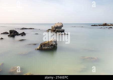 Vue d'art minimaliste des rochers dans la mer prise avec la technique d'exposition longue Banque D'Images