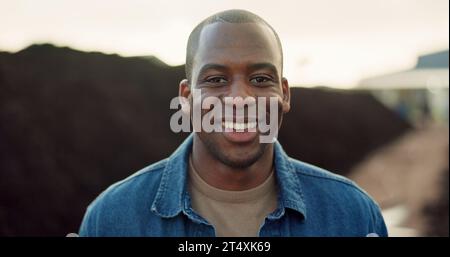 Heureux, portrait et homme noir en plein air sur la ferme, la terre et l'agriculture écologique avec serre au Nigeria. Africain, agriculteur et sourire pour travailler dans Banque D'Images