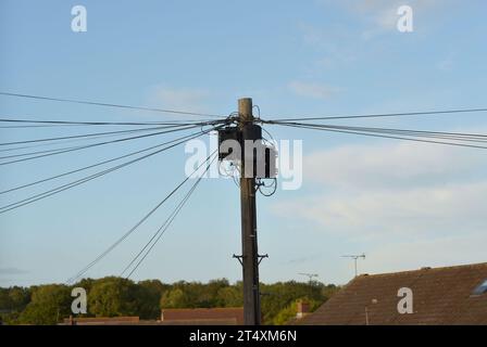 Une vue des câbles BT et des boîtes de commutation sur un poteau télégraphique à Billericay, Essex. Au Royaume-Uni, les entreprises de télécommunications remplacent la technologie qu'elles utilisent pour fournir des réseaux téléphoniques fixes (lignes fixes). Pour la plupart des clients, la mise à niveau devrait être terminée d'ici 2025. Date de la photo : jeudi 26 octobre 2023. Banque D'Images