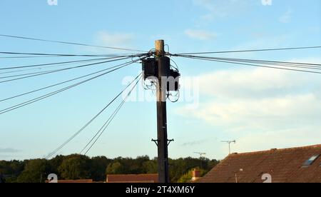 Une vue des câbles BT et des boîtes de commutation sur un poteau télégraphique à Billericay, Essex. Au Royaume-Uni, les entreprises de télécommunications remplacent la technologie qu'elles utilisent pour fournir des réseaux téléphoniques fixes (lignes fixes). Pour la plupart des clients, la mise à niveau devrait être terminée d'ici 2025. Date de la photo : jeudi 26 octobre 2023. Banque D'Images