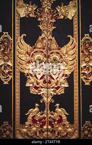 Deux portes en bois décorées avec goût, peintes dans des tons or et rouge, situées dans le grand intérieur du palais de Buckingham à Londres, en Angleterre Banque D'Images