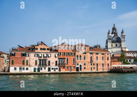 Bâtiments colorés sur la promenade de Zattere, avec des clochers et le dôme de la Basilica di Santa Maria della Salute au-delà à Venise, région de Vénétie, Italie Banque D'Images