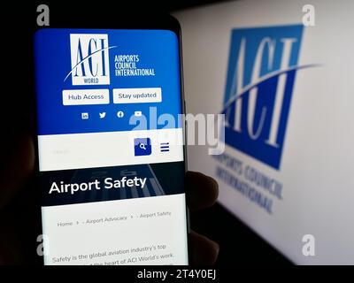 Personne tenant un téléphone cellulaire avec la page Web de l'organisation Airports Council International (ACI) devant le logo. Concentrez-vous sur le centre de l'écran du téléphone. Banque D'Images