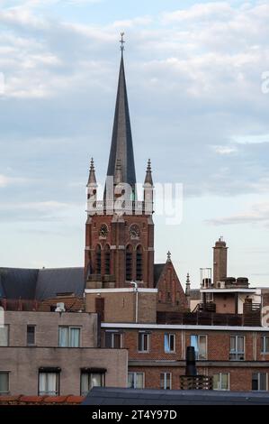 Jette, région de Bruxelles-capitale, Belgique, le 19 octobre 2023 - l'église Sainte-Marie-Madeleine avec des immeubles au premier plan Banque D'Images