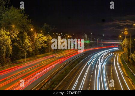 Trafic de banlieue approchant du rond-point Riverside pris avec une longue exposition, Northampton, Angleterre, Royaume-Uni. Banque D'Images