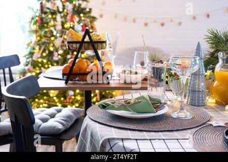 Servant une table de fête avec des collations, des salades et des goodies en gros plan dans l'intérieur moderne d'une maison loft décorée pour Noël et le nouvel an. En attente Banque D'Images