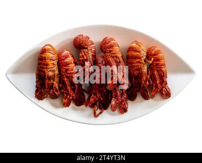 Homards européens bouillis (Scyllarus arctus) sur une assiette sur fond blanc - fruits de mer de grande valeur du nord de l'Espagne communément appelés 'santi Banque D'Images